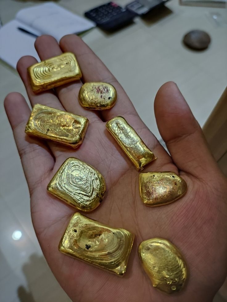 Raw gold nuggets held in a hand
