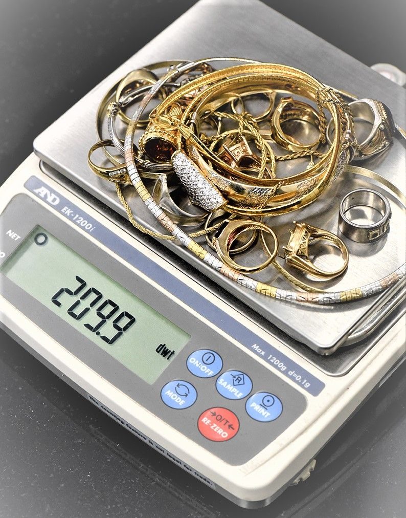 Scrap gold jewellery being weighed on a digital scale